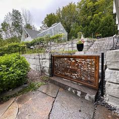 a wooden bench sitting next to a stone wall