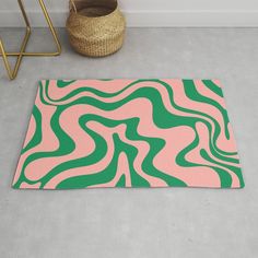 a pink and green rug on the floor next to a basket