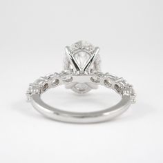 a white gold engagement ring with an oval cut diamond in the center and side stones