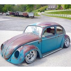 an old blue and brown car parked in a parking lot