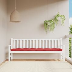 a white bench sitting on top of a hard wood floor next to a plant filled wall