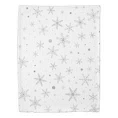 a white napkin with silver snowflakes and stars on the front, against a white background