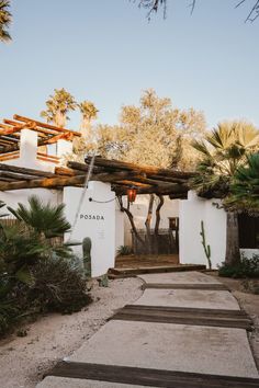 the entrance to an adobe - style home with wooden steps leading up to it and palm trees in the background