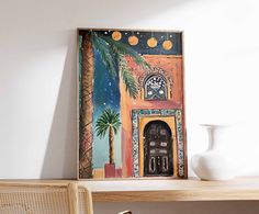 a painting hanging on the wall next to a chair and table with a potted plant