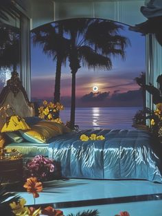 a bed sitting in front of a window next to flowers and palm trees at night