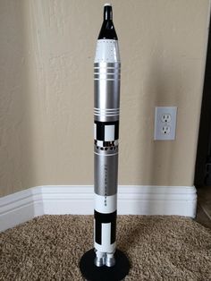 a model rocket sitting on top of a carpeted floor next to a light switch