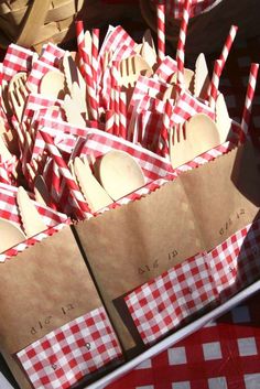 red and white checkered table cloth with wooden utensils in brown paper bags