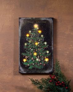 a small christmas tree with lights is on the wall next to a potted plant