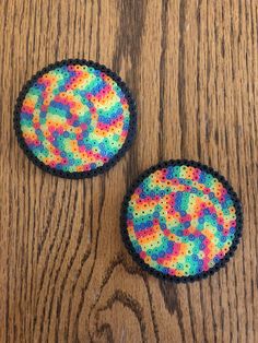 two colorful buttons sitting on top of a wooden table