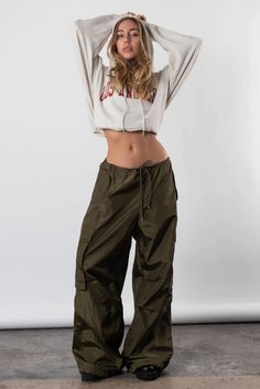 Take Us Back Parachute Pant In Olive Green – Resurrection Parachute Pants Photoshoot, Winter Utility Nylon Parachute Pants, 90s Style Cargo Pants For Fall Streetwear, 90s Style Bottoms With Cargo Pockets For Streetwear, 90s Style Cargo Pockets Bottoms For Streetwear, Fall Athleisure Cargo Style Pants, 90s Cargo Bottoms For Streetwear, Casual Cargo Style Parachute Pants For Winter, Casual Winter Parachute Cargo Pants