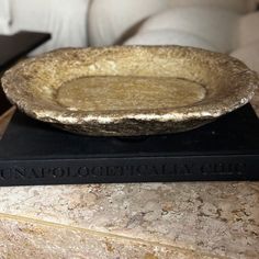 a golden bowl sitting on top of two black books