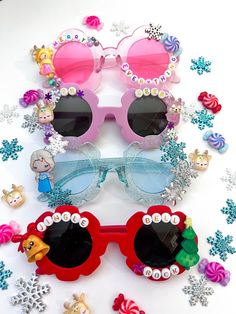 "CHRISTMAS SUNNIES!! These are so adorable-- Each pair is handcrafted by me. Using various beads, Charms, Rhinestones, and fun details! ♥️💚 *4 options available-- Choose your style:  1. JINGLE BELL ROCK 2. OH DEER 3. ELSA (you can add personalized, like a name. (It's optional)  4. MERRY EVERYTHING  * Anti-Glare * UV Protection (UVA & UVB) * Durable and shatterproof  * They open and close smoothly  * Each item is made to order and will be ready to ship in 5-7 business days! If you need your order sooner. Please check out my \"RUSH ORDER OPTION\".  https://www.etsy.com/EyeCandyandFluff/listing/1286351273/rush-my-order-please *SHOP DISCLAIMER/WAIVER!  * Do NOT let your child put the sunglasses in their mouth as beads can become detached.    Always monitor and supervise while children are wea Fun Handmade Sunglasses As A Gift, Playful Adjustable Sunglasses As A Gift, Novelty Sunglasses With Tinted Lenses As Gift, Novelty Sunglasses With Tinted Lenses For Gift, Cute Customizable Sunglasses For Gift, Diy Kids Sunglasses, Fun Handmade Sunglasses For Parties, Fun Handmade Sunglasses For Party, Playful Personalized Sunglasses For Party