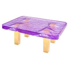 a purple table with gold legs and a plastic cover on it's top is shown in front of a white background