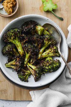 a white bowl filled with broccoli on top of a wooden table