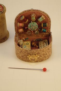 an old sewing box with various items inside