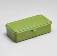 a green lunch box sitting on top of a white table