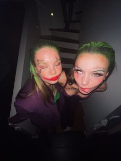 two women with makeup on their faces posing for the camera