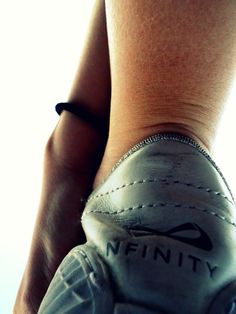 a close up of a person's foot wearing white tennis shoes with the wordfinity written on it