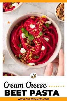 a bowl filled with beet pasta and topped with chopped nuts