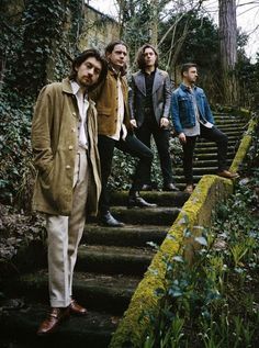 four men standing on steps in the woods