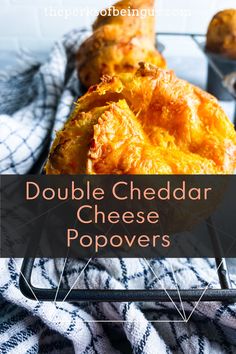 two cheesy potatoes sitting on top of a metal tray with the words double cheddar cheese popovers