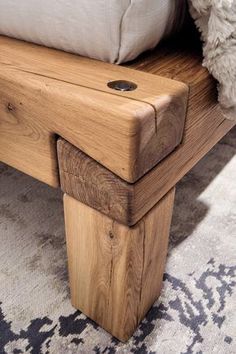 a wooden bench sitting on top of a carpeted floor next to a white pillow