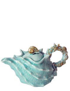 a ceramic teapot shaped like a seashell