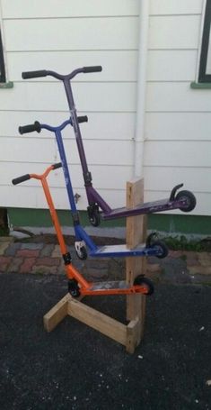 three scooters are stacked on top of one another in front of a building