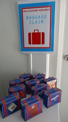 there are many blue boxes on the table with luggage tags attached to them and a sign that says bagage claim