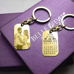 two personalized keychains on top of a purple book with a couple's photo