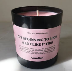 a candle with a pink label on it that says, it's beginning to look alot like this