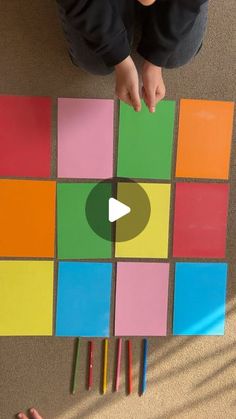 a person sitting on the floor with some colored squares