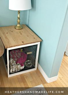 a small cage is on top of a table next to a lamp