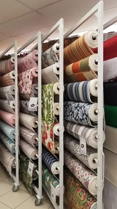 a rack full of different colored fabrics in a store