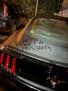 a car parked in front of a building with writing on the hood and back window