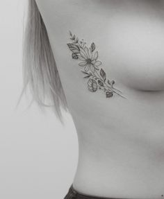 black and white photo of a woman's breast with flowers on it, tattoo style