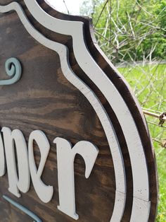 a wooden sign with the name spencer on it's side and trees in the background