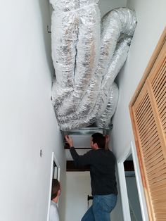 two men working on an air duct system