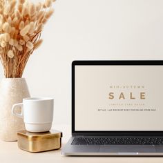 an open laptop computer sitting on top of a desk next to a cup and saucer