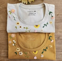 three t - shirts with embroidered flowers on them