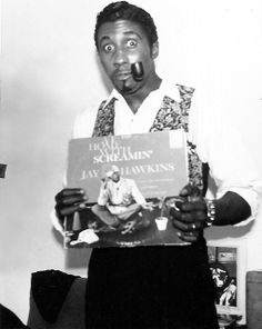 a man holding up a book in front of his face and making a funny face