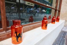 several orange vases sitting in front of a window on the side of a building