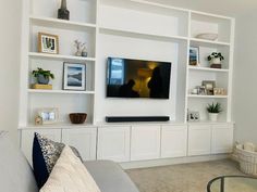 a living room filled with furniture and a flat screen tv on top of a wall