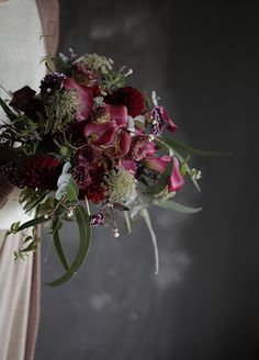 a woman holding a bouquet of flowers in her hands