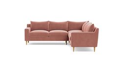 a pink sectional sofa with pillows on the back and armrests, in front of a white background