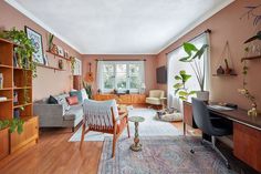 a living room filled with furniture and lots of plants on top of it's shelves