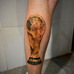 a man's leg with a tattoo on it that has an image of the world cup