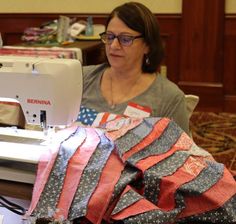 a woman sitting in front of a sewing machine