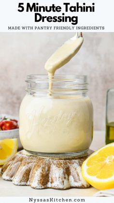 a mason jar filled with pudding and topped with whipped cream next to sliced lemons