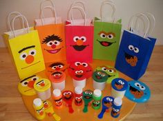 the sesame street characters are all lined up on the table with plastic cups and toothbrushes